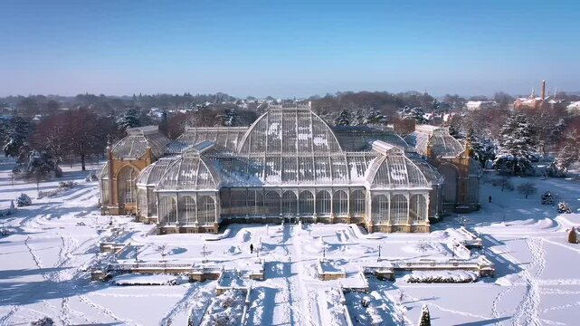 Snowy Landscape View of Large Glass Greenhouse in Winter Scenic Park