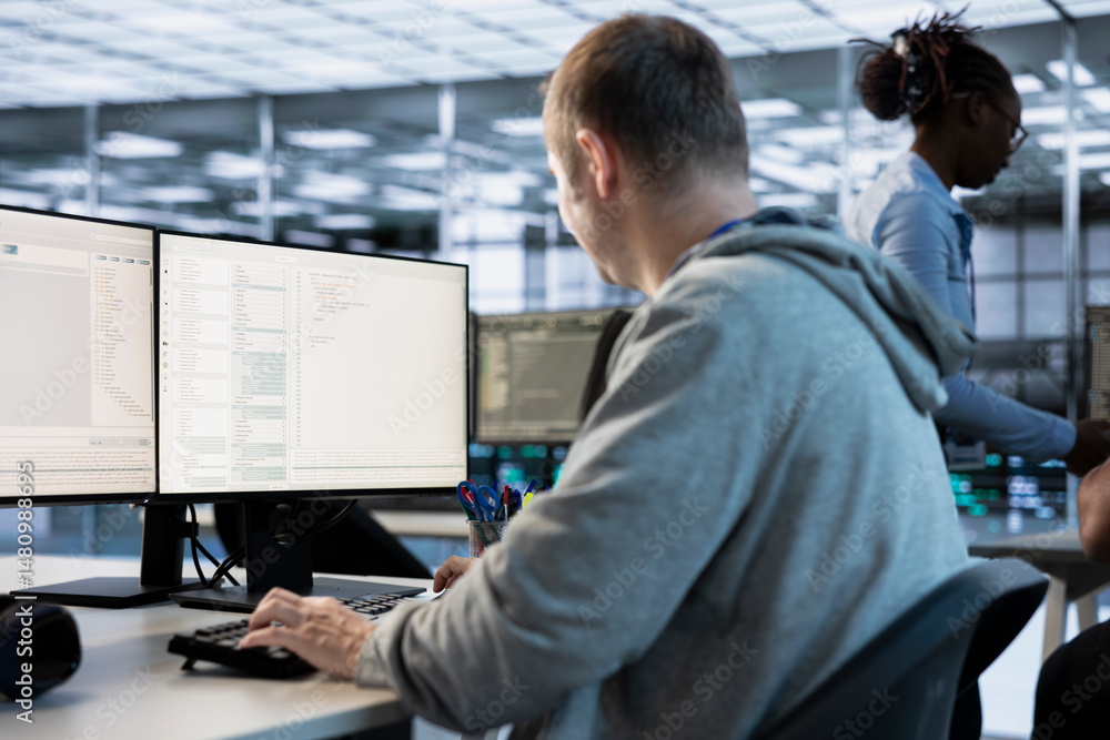 Poster it engineer looking at pc screen, working in network security data center, ensuring optimal performa