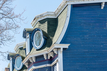 The second story floor of a vintage Second Empire style house with navy blue narrow clapboard...