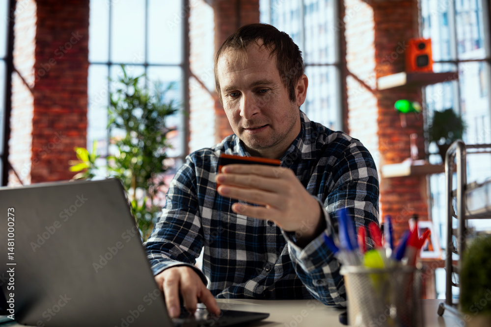 Poster man doing internet shopping, typing credit card information on laptop, placing items in cart, advanc