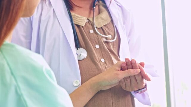 Well wisher doctor gently touches the patient's hand encourage the patient who is stressed by depression from her chronic illness, to help her relax.