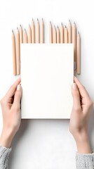 Hands Holding Blank Paper with Pencils on White Background