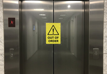 An elevator door displaying an "Out of Order" sign, indicating it is currently non-functional