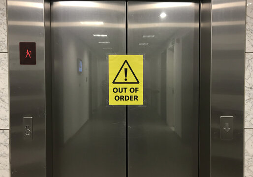 An elevator door displaying an "Out of Order" sign, indicating it is currently non-functional