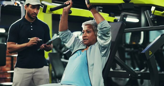 Fitness, woman and high five on machine with personal trainer for workout goal or exercise success. Senior person, happy coach or celebration in gym for muscle, body health or chest press with tablet