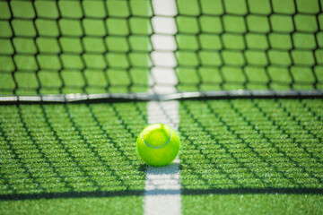 Minimalist padel setup with bright ball on green playing surface. Great for fitness posters, digital sports content and mobile apps
