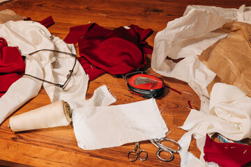 Crafting chaos in a sewing workspace with fabric remnants and tools scattered across a wooden table