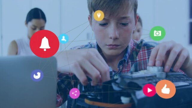 students assembling robotics kit at workbench in tech classroom, with floating social media icons