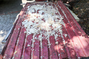 Rice Spilled on Rusty Red Metal Surface on Surface with Leaves