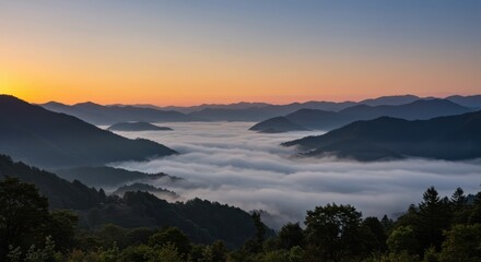 Obraz premium Mountain range at sunrise representing serenity and natural beauty, with foggy valley
