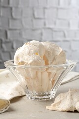 Delicious homemade meringue cookies in bowl on gray table