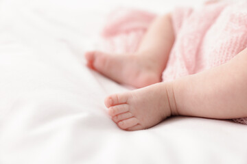 Cute little baby lying on bed at home, closeup. Space for text