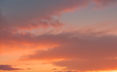 Fototapeta premium Sky with clouds showing shades of orange pink and purple during sunset.