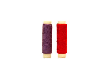 Red spool and Purple spool of sewing thread isolated on white background 