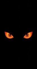 Glowing orange spooky eyes in the dark