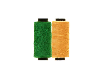 Green spool and Yellow spool of sewing thread isolated on white background 