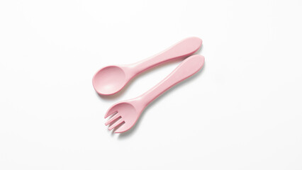 Pink baby spoon and fork set on white background. Minimalist baby feeding utensils, ideal for product mockup or parenting-themed content.