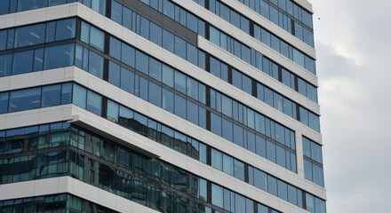 Modern building reflecting urban progress and growth, with glass windows and white facade