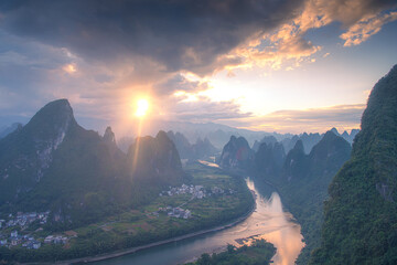 First rays of light through the clouds in Xianggong hill of Guilin, Li River and Karst mountains