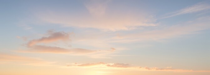 Obraz premium Sky with clouds in light blue pink and yellow colors at sunset.