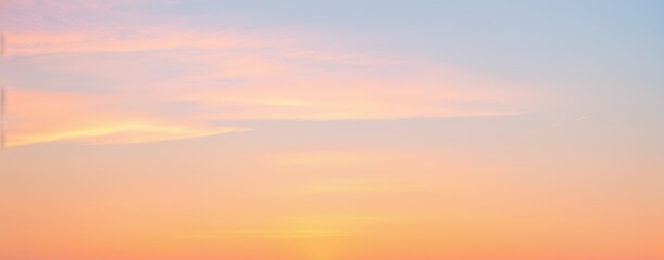Obraz premium A gradient sky displays soft colors of orange pink and blue at sunrise.