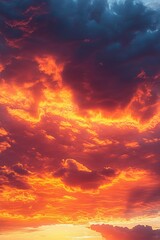 Fototapeta premium Dramatic vibrant sunset sky with fiery orange and red clouds blending into deep blue and purple hues, creating a powerful and intense atmosphere