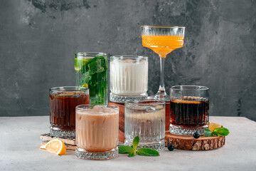 Various alcoholic cocktails with gin and whiskey and Cola on the table decorated with mint and citrus