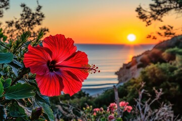 Vibrant hibiscus flower at sunrise over a beach. Lush foliage surrounds the bloom, against a backdrop of golden sunset