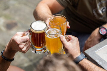 Couple celebrating and cheering with beer pints for National Beer Lover's Day.