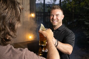 Friends celebrating and cheering with beer pints for National Beer Lover's Day.