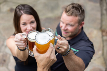 Friends celebrating and cheering with beer pints for National Beer Lover's Day.