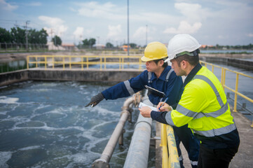 A professional engineer and technician are working together to seriously check the water quality in a water treatment pond.