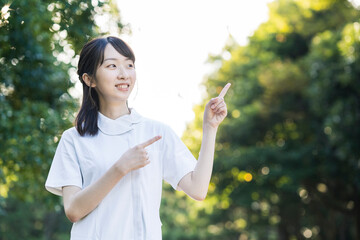 指差しポーズをする白衣の女性