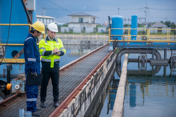 An inspector and an engineer at a water treatment plant are working together to plan the installation of additional water filters to make the water cleaner and safe for household use.