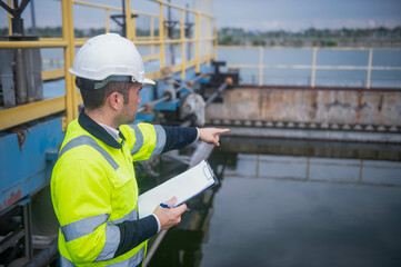 A professional inspector is checking the water filtration system of a wastewater treatment plant to...