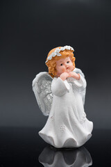 white angel trinket on a black background