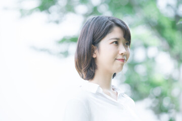 Fototapeta premium 木々に癒される若い女性