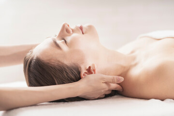 エステサロンで首をマッサージされる若い女性