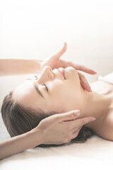 エステサロンで首をマッサージされる若い女性