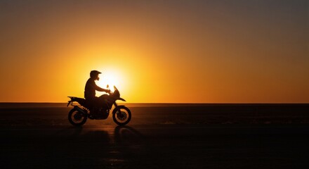 Fototapeta premium Motorcycle rider silhouette at sunset, adventure touring bike, golden hour, freedom, travel, horizon view