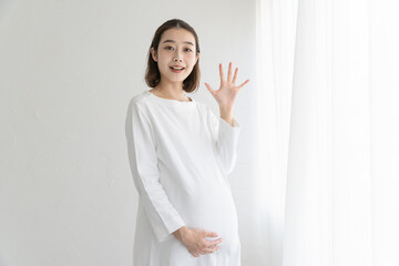 「こんにちは」と手を振る妊婦