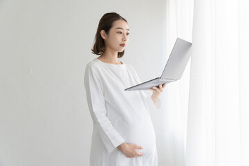 パソコンの画面を見る妊婦