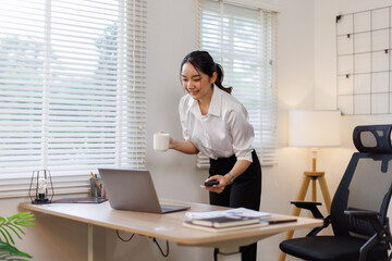 Cheerful business Asian woman holding telephone call share good news about project working in office workplace, concept of Business woman working.