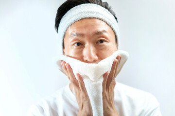 タオルで顔をふく日本人の中年男性