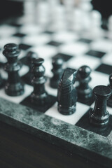 Artistic close-up of black chess pieces on a marble board, highlighting strategic gameplay and...
