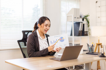 Financial Business asian woman analyze the graph of the company's performance to create profits and growth, Market research reports and income statistics, Financial and Accounting concept.
