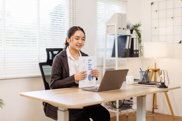 Financial Business asian woman analyze the graph of the company's performance to create profits and...