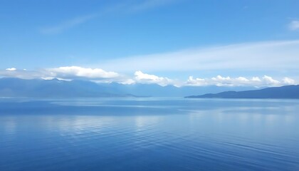 Serene aquatic scenery displaying a blue horizon with mountains and fluffy clouds