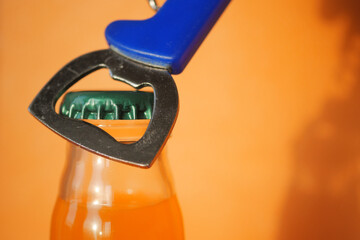 Opener removes soda cap on orange BG