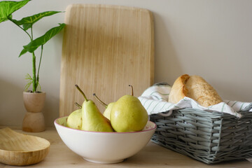 Fresh pears and bread arranged on a wooden table